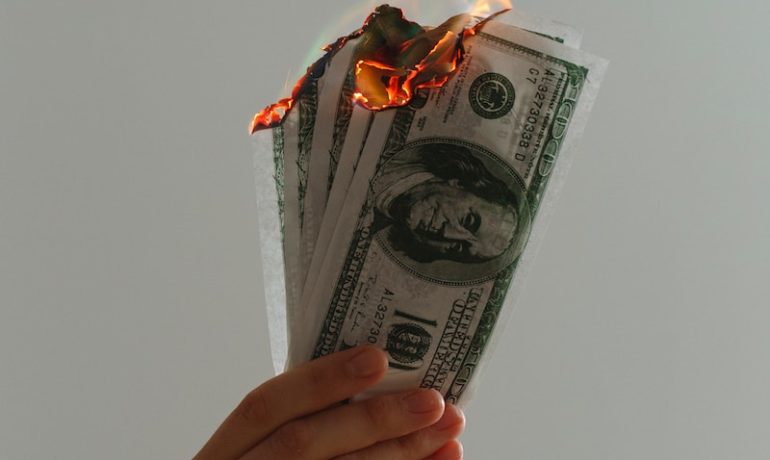time lapse photography of several burning US dollar banknotes